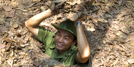 Vietnamesisk rejseguide i en cu chi tunnel