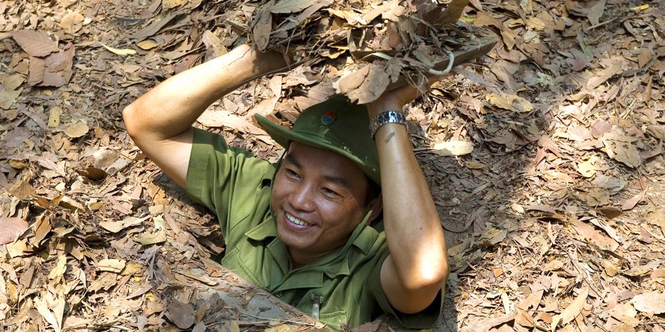 Vietnamesisk rejseguide i en cu chi tunnel